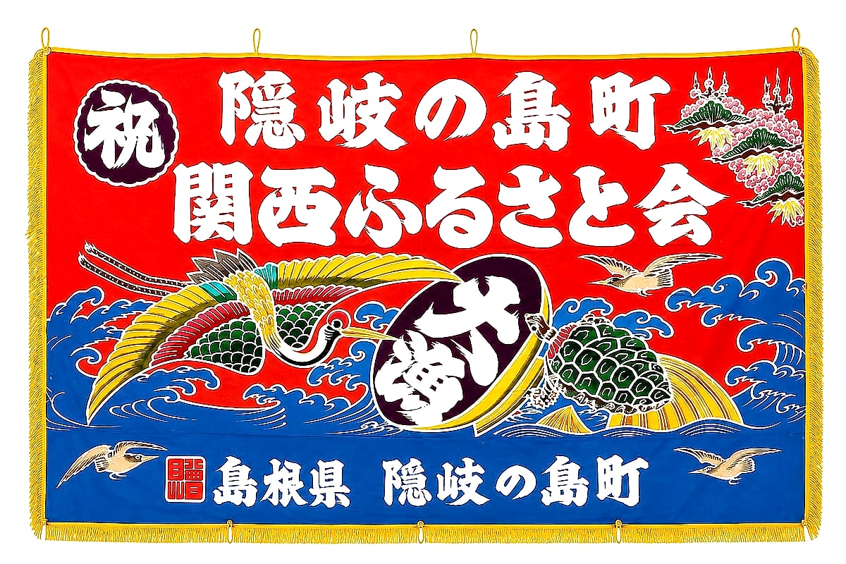 隠岐の島町関西ふるさと会の会旗（大漁旗）。鳳凰・海亀・荒波が色鮮やかに描かれ、祝 隠岐の島町 関西ふるさと会、島根県 隠岐の島町と記されている。